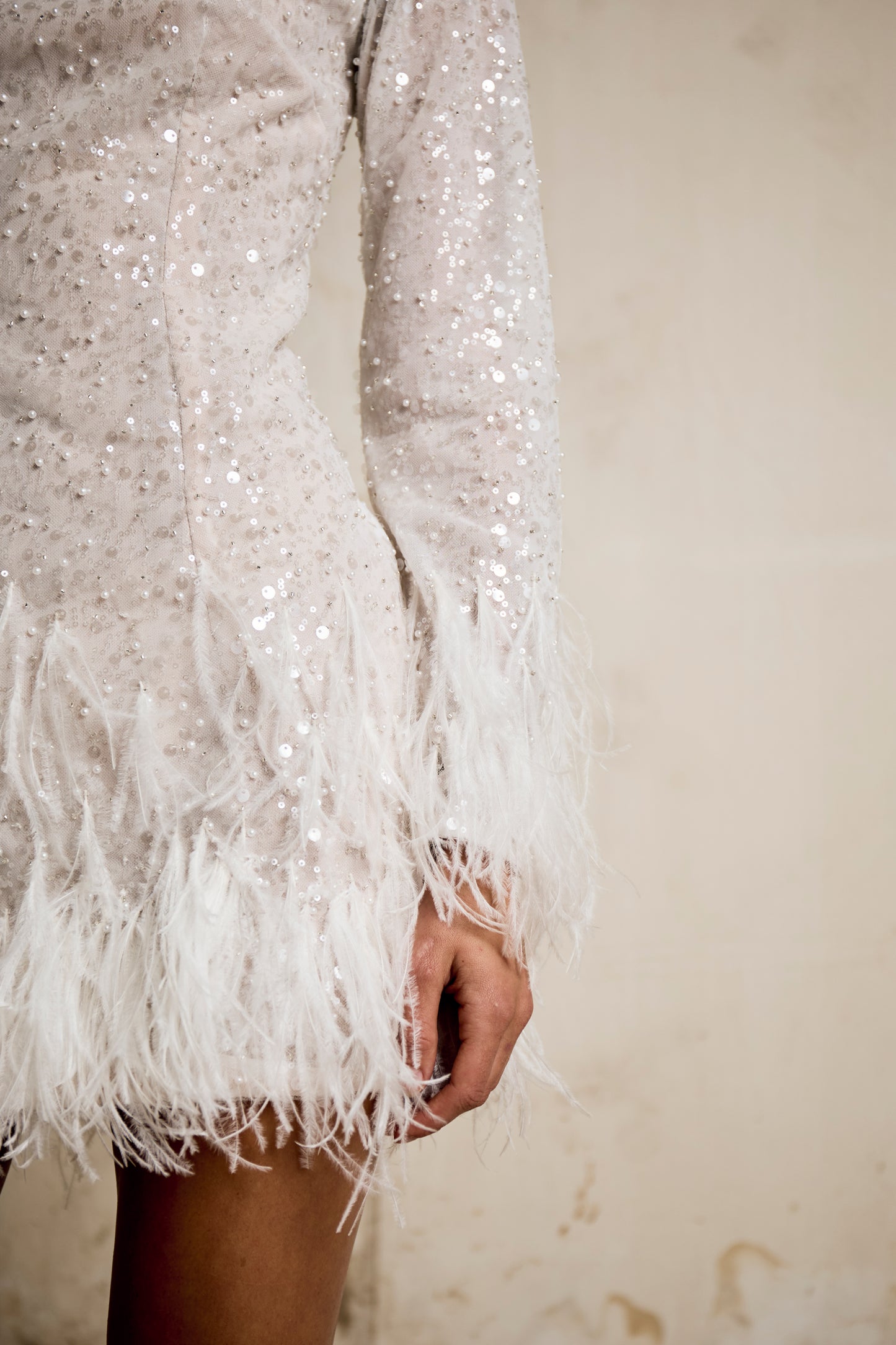 Long sleeved fully sequined wedding reception dress with ostrich feather trim skirt for brides.