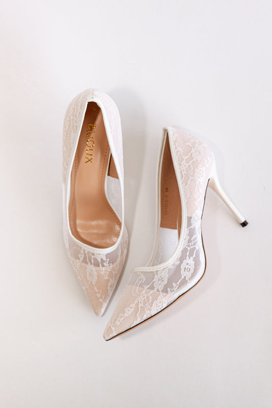 Pair of white lace high heels with pointy toe and stiletto heel